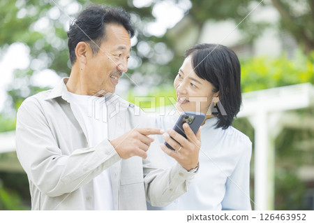 一對老夫妻在戶外看智慧型手機 126463952