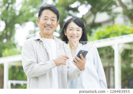 一對老夫妻在戶外看智慧型手機 一對老夫妻在戶外看智慧型手機 126463955