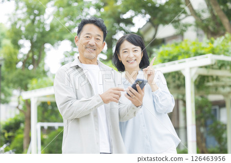 一對老夫妻在戶外看智慧型手機 126463956