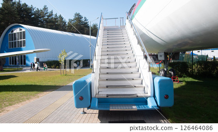 A vintage Soviet aircraft stands in a museum, featuring a set of stairs attached for visitors to explore. This exhibition highlights significant aviation history. 126464086
