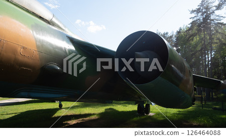 A vintage Soviet aircraft stands proudly in a forest area in Russia, showcasing its unique design and military history. The sunlight highlights its features. 126464088