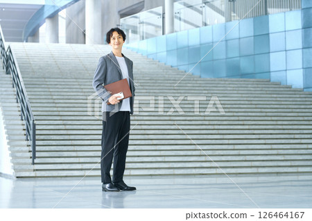 穿著商務休閒服的男工程師站在辦公室入口處 126464167