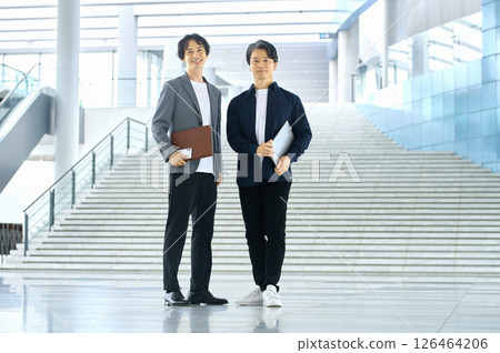 Two businessmen (plain clothes) having a meeting in the aisle 126464206