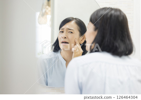 Senior woman watching a mirror Senior woman watching a mirror 126464304