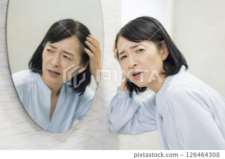Senior woman watching a mirror 126464308