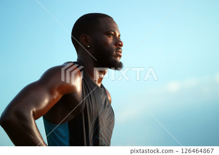 Determined Athlete Training Under a Clear Sky During Sunset at the Track 126464867