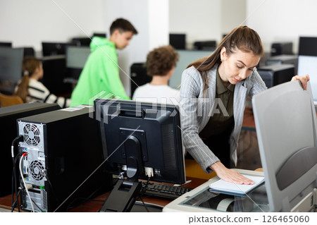Teacher using scanner in computer class 126465060