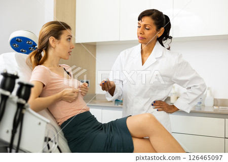 Plastic surgeon and woman discussing breast augmentation Plastic surgeon and woman discussing breast augmentation 126465097