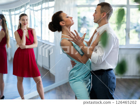 Woman tango instructor dancing with male student in studio 126465202