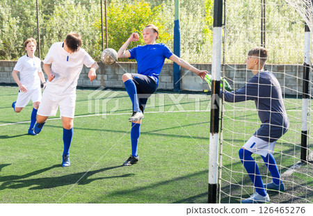 Youthful football players challenging for ball Youthful football players challenging for ball 126465276