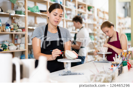 Young woman painting ceramic cup in ceramic workshop Young woman painting ceramic cup in ceramic workshop 126465296