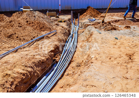 Many electrical conduits are being installed in trench at construction site emphasizing industrial 126465348