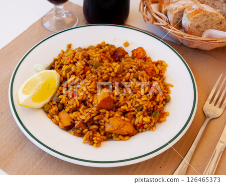 Meat paella with lemon on white plate Meat paella with lemon on white plate 126465373