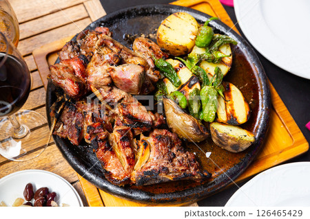 dinner served for two person of grilled beef tenderloin with potatoe and pepper in iron frying pan dinner served for two person of grilled beef tenderloin with potatoe and pepper in iron frying pan 126465429