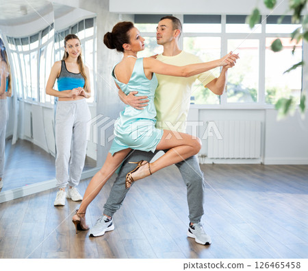 Woman tango instructor dancing with male student in studio 126465458