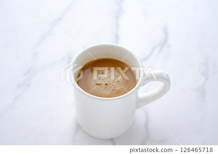 Image of a person relaxing while drinking a cafe latte, a coffee made from espresso and milk Image of a person relaxing while drinking a cafe latte, a coffee made from espresso and milk 126465718