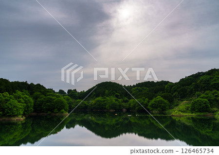 奈良縣奈良市佈目水壩,薄薄的雲層中透出的陽光,倒映在如鏡的湖面上,映照著天空。 ③ 奈良縣奈良市佈目水壩,薄薄的雲層中透出的陽光,倒映在如鏡的湖面上,映照著天空。 ③ 126465734