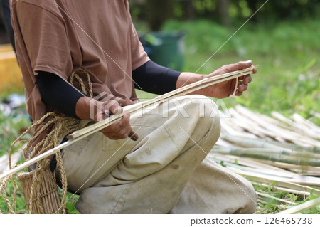 A man cutting bamboo to the same length A man cutting bamboo to the same length 126465738