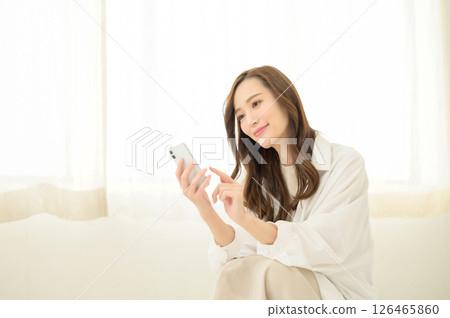 A woman watching video content on her smartphone A woman watching video content on her smartphone 126465860