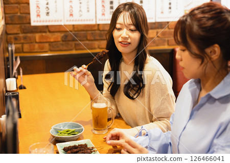 Woman sitting at the counter of an izakaya Woman sitting at the counter of an izakaya 126466041