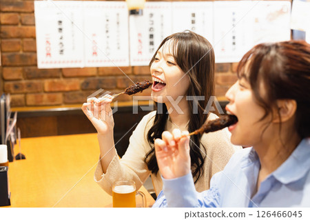 A woman eating at an izakaya 126466045