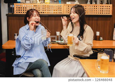 A woman eating at an izakaya A woman eating at an izakaya 126466048