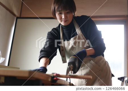一名婦女用電鋸切割木材 126466066