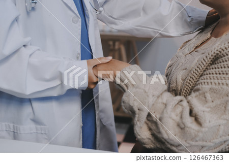 Medicine doctor hand reassuring her female patient Medicine doctor hand reassuring her female patient 126467363