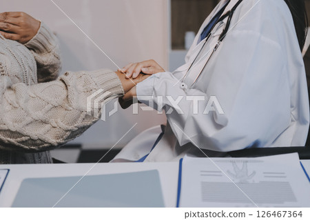 Medicine doctor hand reassuring her female patient Medicine doctor hand reassuring her female patient 126467364