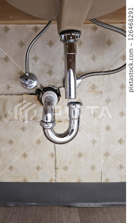 Exposed Plumbing Underneath a Bathroom Sink with a P-Trap and Supply Lines, Home Repair Exposed Plumbing Underneath a Bathroom Sink with a P-Trap and Supply Lines, Home Repair 126468291