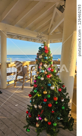Beautiful Christmas Tree with Colorful Ornaments on a Beachfront Deck Scenery Beautiful Christmas Tree with Colorful Ornaments on a Beachfront Deck Scenery 126468293