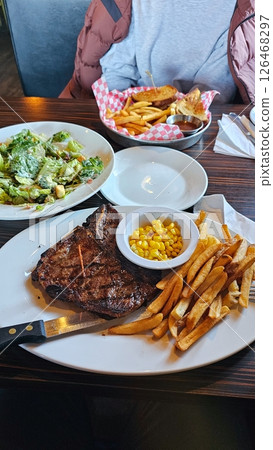 Hearty Steak Dinner with Salad, Fries, and Corn A Delicious and Satisfying Meal Experience Hearty Steak Dinner with Salad, Fries, and Corn A Delicious and Satisfying Meal Experience 126468297