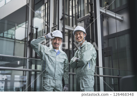 Two smiling workers looking at the camera, building maintenance staff image 126468348