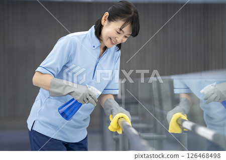 Image of building cleaning: Cleaning staff wiping handrails in the hallway 126468498