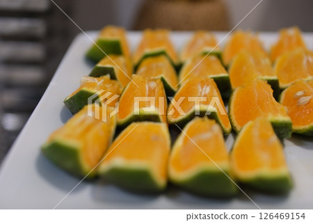 Vietnamese Green Mandarin Orange Sliced orange slices on a plate. Juicy orange. 126469154