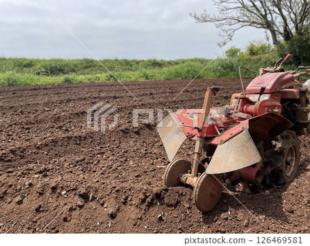 Agricultural tractor plowing a field 126469581