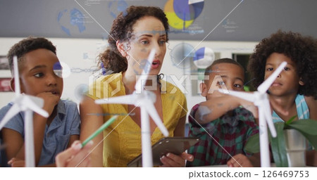 Image of diagrams and data processing over diverse female teacher and schoolchildren learning 126469753