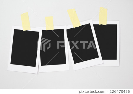 Four blank polaroid photo papers stuck with sticky tape on a white background. Mockup, template, or copy space. Instant camera photo print frame 126470456