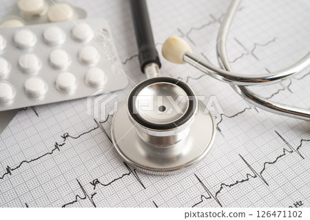 Stethoscope on electrocardiogram ECG with capsule drug, heart wave, heart attack, cardiogram report. 126471102