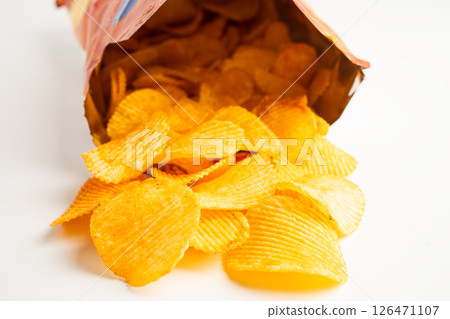 Potato chips, delicious BBQ seasoning spicy for crips, thin slice deep fried snack fast food in open bag. Potato chips, delicious BBQ seasoning spicy for crips, thin slice deep fried snack fast food in open bag. 126471107