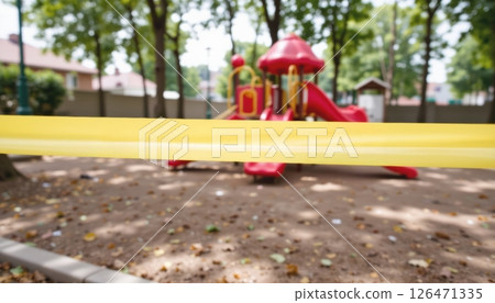 Playground equipment cordoned off with yellow tape under trees. 126471335