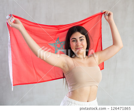 Happy young woman with flag of Monaco against unicoloured background Happy young woman with flag of Monaco against unicoloured background 126471865