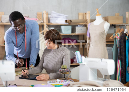 Fashion designers developing new clothing models using table Fashion designers developing new clothing models using table 126471964