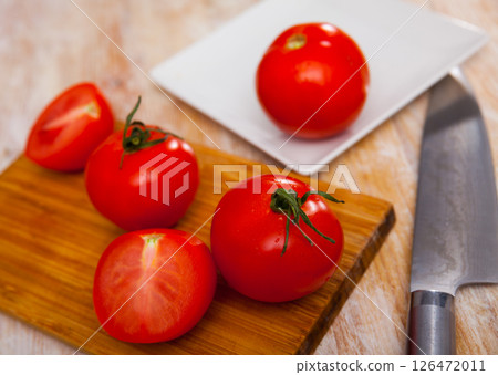 Delicious tomatoes on a wooden chopping board Delicious tomatoes on a wooden chopping board 126472011