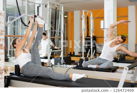 Young woman performing exercises on pilates Cadillac table 126472409
