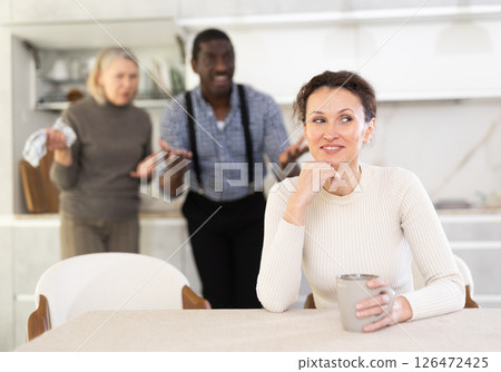 Woman not talking after disagreement with husband and mother standing behind Woman not talking after disagreement with husband and mother standing behind 126472425