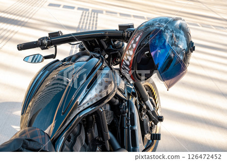 Cool motorbike with helmet on handle of motorcycle the city Cool motorbike with helmet on handle of motorcycle the city 126472452