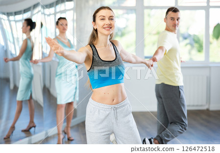 Couple in comfortable sports clothes learns boogie woogie dancing during individual lesson Couple in comfortable sports clothes learns boogie woogie dancing during individual lesson 126472518