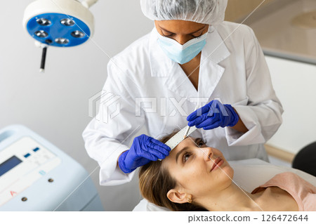 Beautician drawing correction lines on woman face Beautician drawing correction lines on woman face 126472644