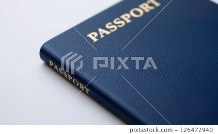 Blue passport on a white surface, emphasizing travel and identity. 126472940